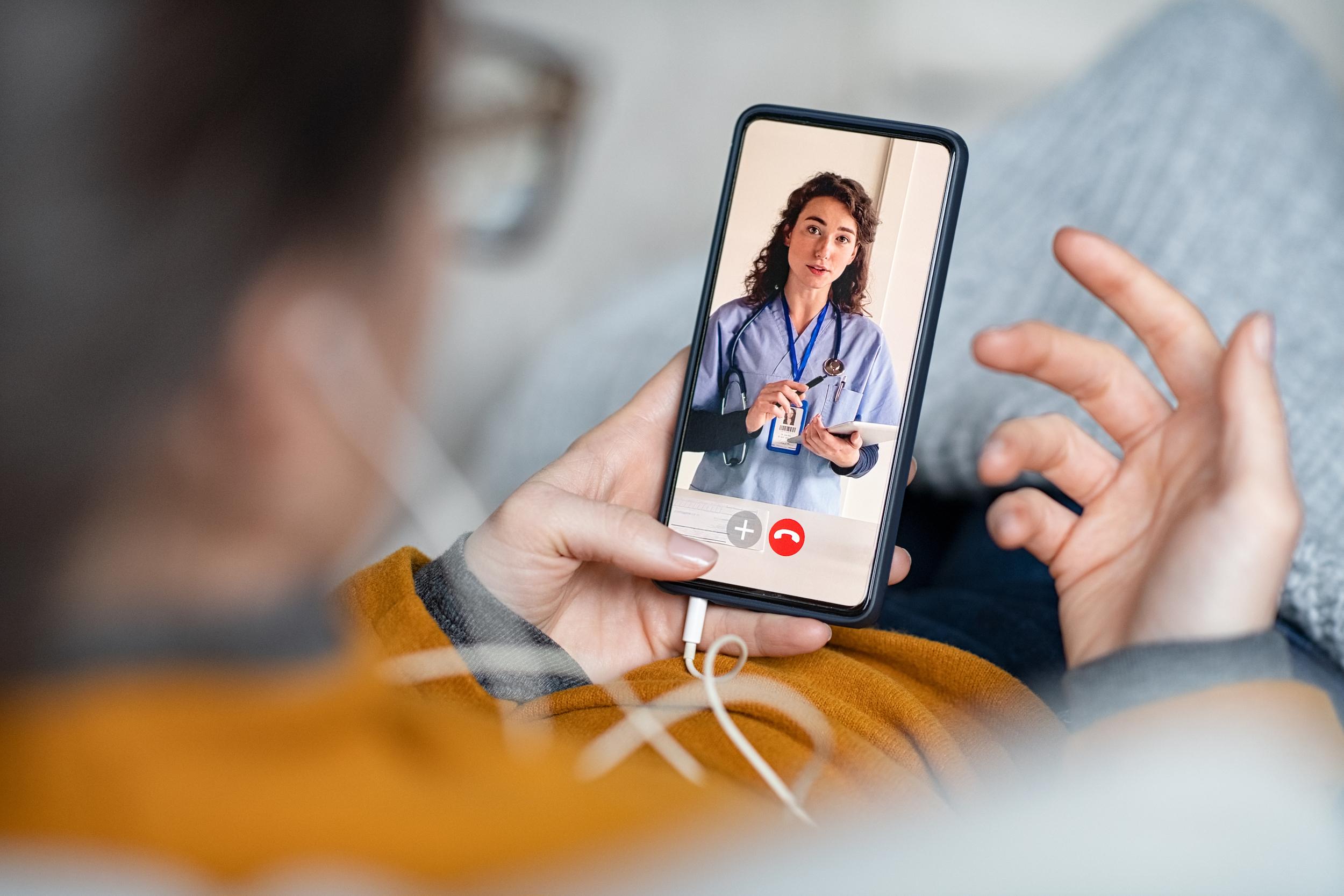 A person is attending a virtual doctor's appointment on their cell phone