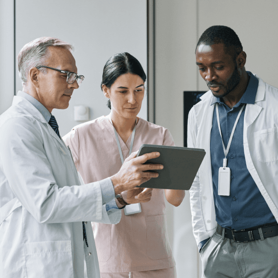 Three doctors looking at a screen