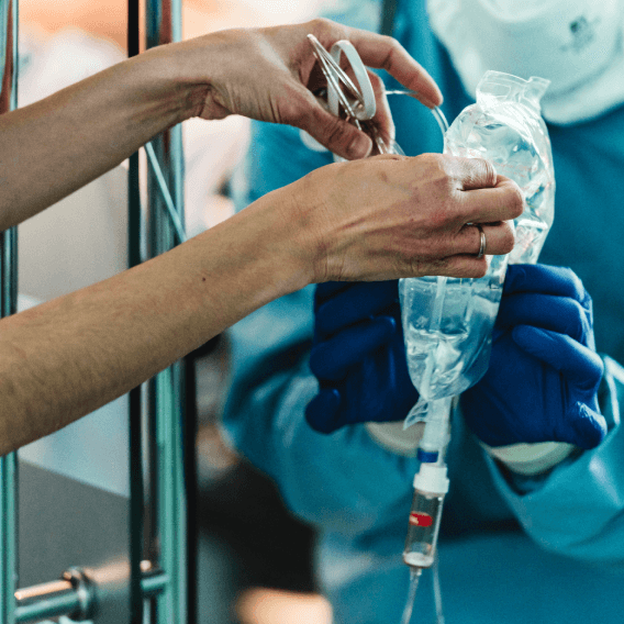 Nurse giving infusion system to doctor