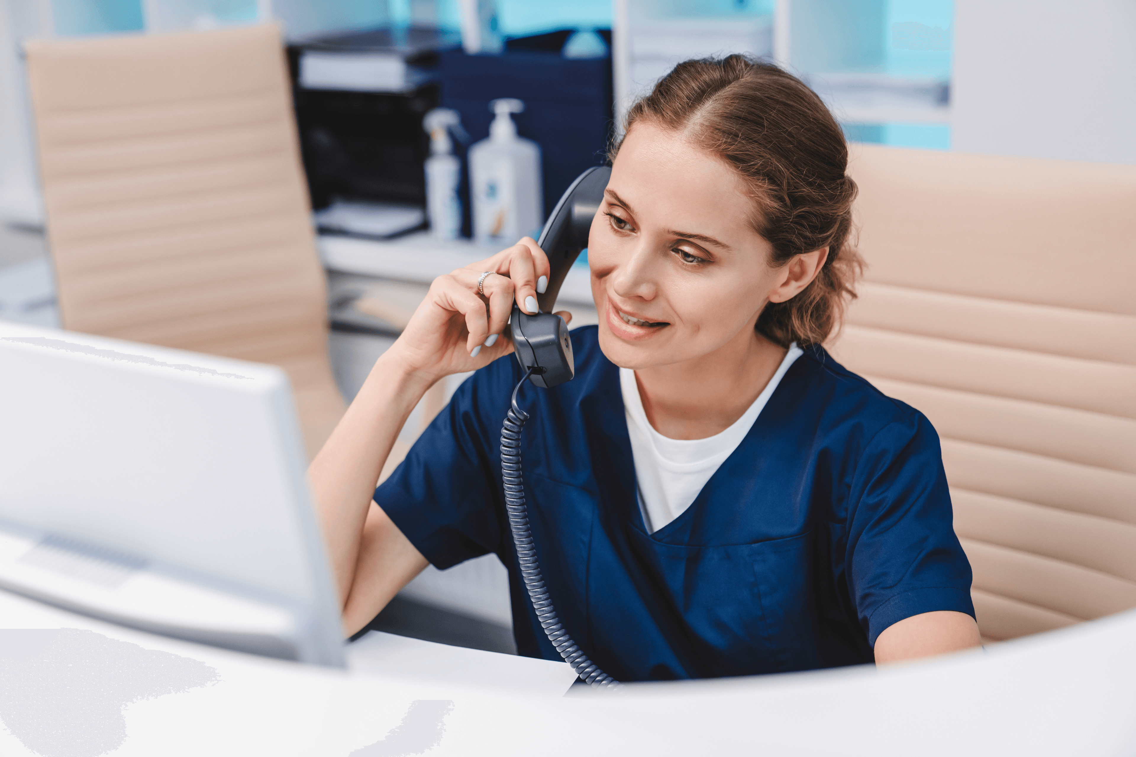 A woman in scrubs speaking on the phone